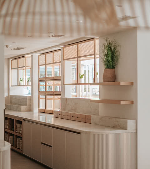 Ein modernes Hotelinterior mit hellen Holzelementen und Pflanzen im Design Hotel Sonnen Resort Naturns.
