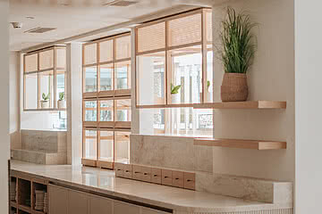 Ein modernes Hotelinterior mit hellen Holzelementen und Pflanzen im Design Hotel Sonnen Resort Naturns.
