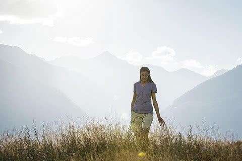 Una donna si gusta la natura durante la vacanza all’insegna del trekking e del wellness al Sonnen Resort Naturno