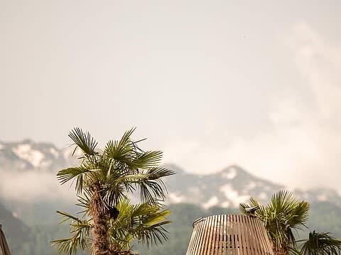 Palmen und moderne Lounge-Bereiche mit Bergblick im Sonnenresort Wellnesshotel in Südtirol.