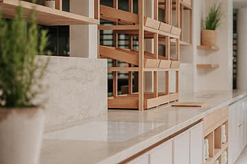 Moderne Innenarchitektur im Design Hotel Sonnen Resort Naturns mit eleganten Holzregalen und Pflanzenakzenten.