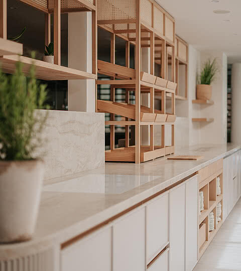 Moderne Innenarchitektur im Design Hotel Sonnen Resort Naturns mit eleganten Holzregalen und Pflanzenakzenten.
