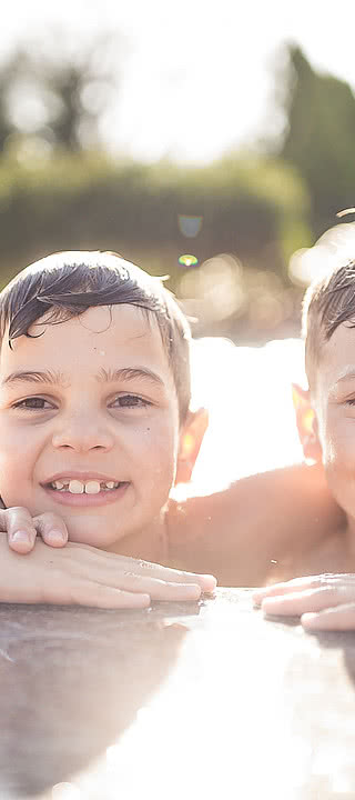 I bambini mentre giocano nella piscina all’esterno nel Wellness e Family Hotel Sonnen Resort