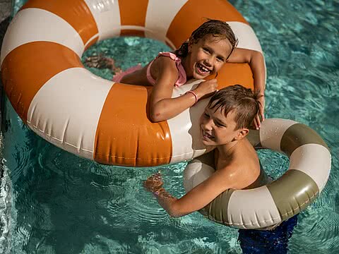 Kinder mit Schwimmreifen im Familienurlaub im Wellnesshotel Sonnen Resort Naturns Südtirol