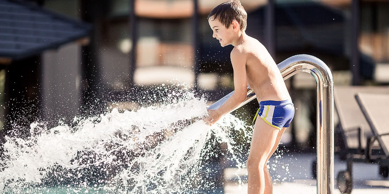 I bambini mentre giocano nella piscina all’esterno nel Wellness e Family Hotel Sonnen Resort