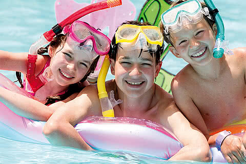 Children playing in the outdoor pool in the wellness and family hotel Sonnen Resort