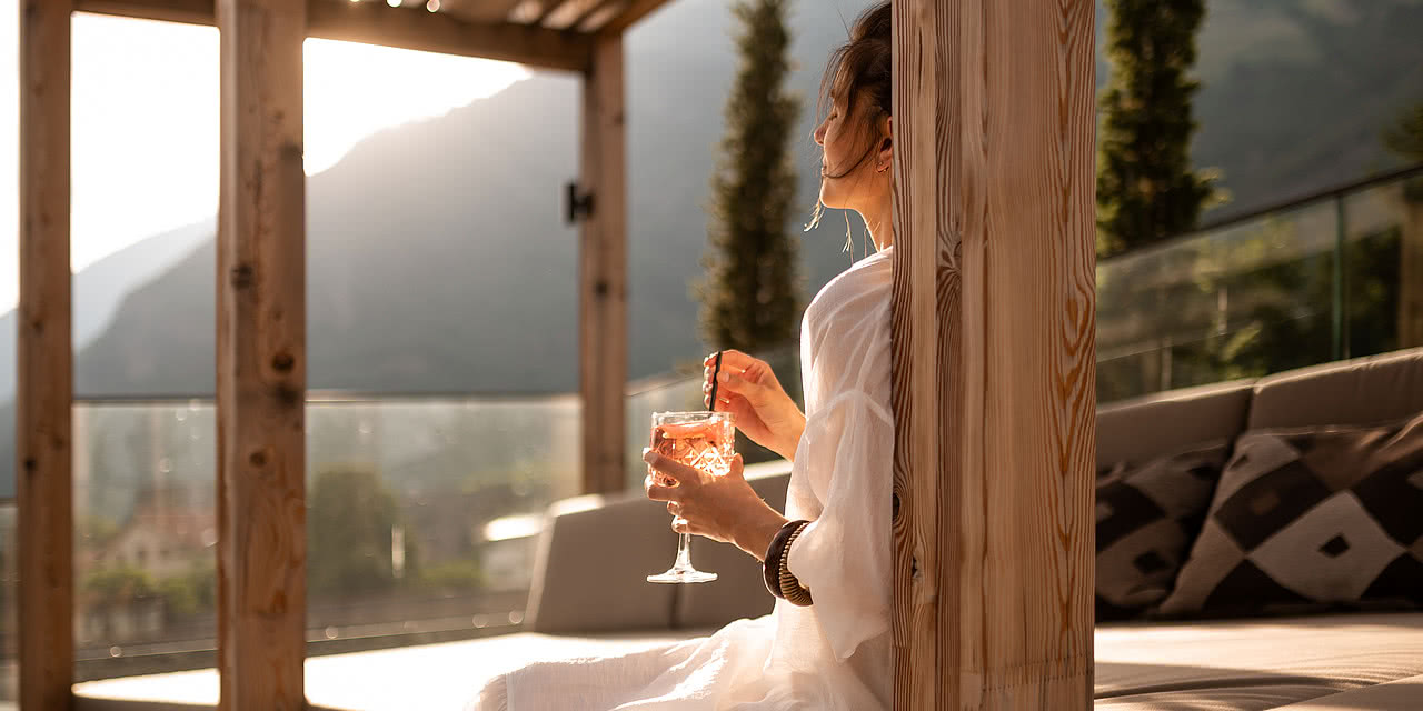 Frau beim Entspannen im Rooftop-Wellnessbereich im Sonnen Resort in Südtirol