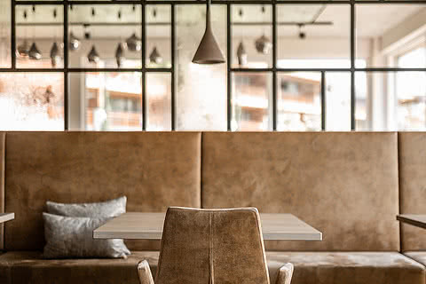 Tisch mit Sessel im Restaurant des Genusshotels Sonnen Resort in Naturns.