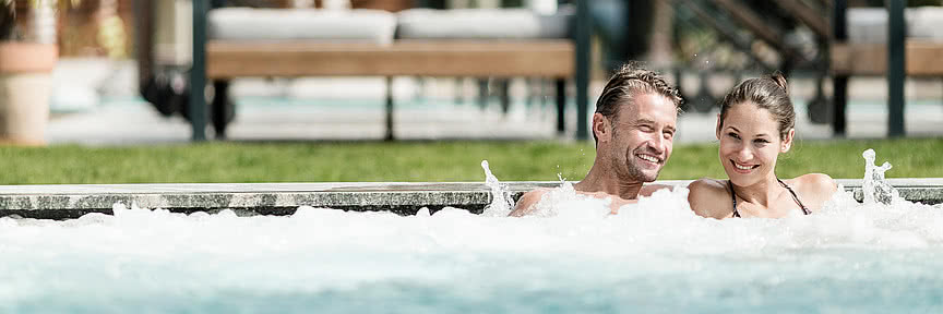 Una coppia rilassata nella piscina outdoor del Wellness Hotel Sonnen Resort in Alto Adige