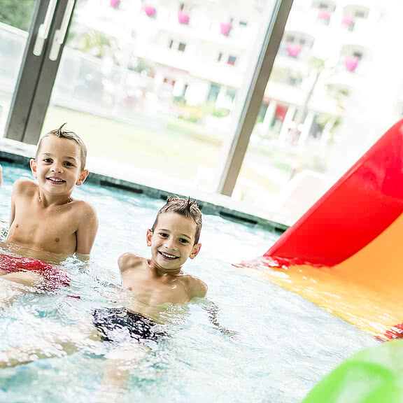 I bambini mentre giocano nella piscina all’esterno nel Wellness e Family Hotel Sonnen Resort